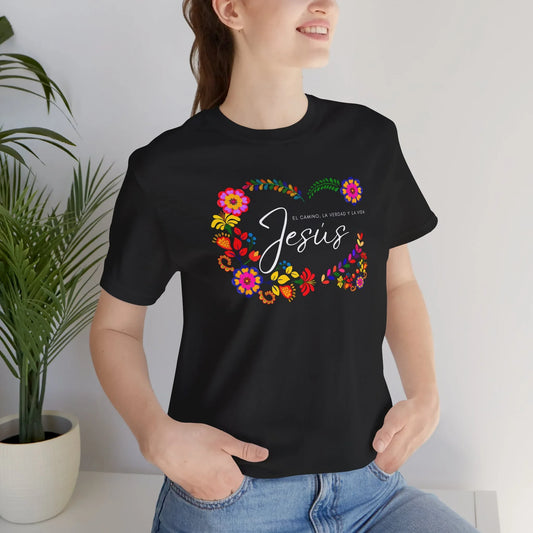 Woman wearing black Christian floral t-shirt with 'Jesus' and Spanish Scripture, casual style