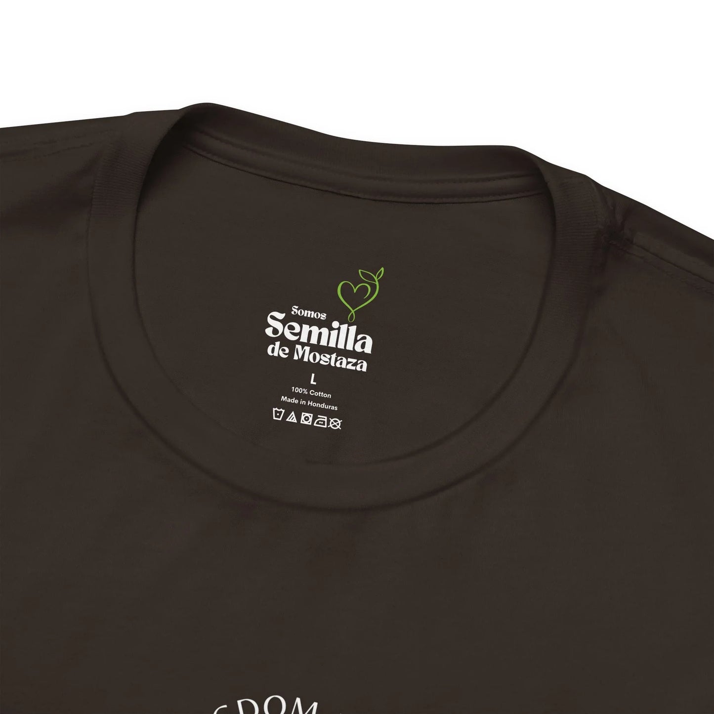 Close-up of black Christian t-shirt label with 'Semilla de Mostaza' text and care symbols