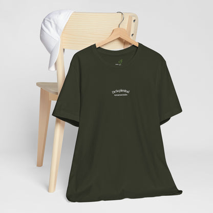 Olive green Christian t-shirt with Spanish faith quote on hanger, white cap on wooden chair
