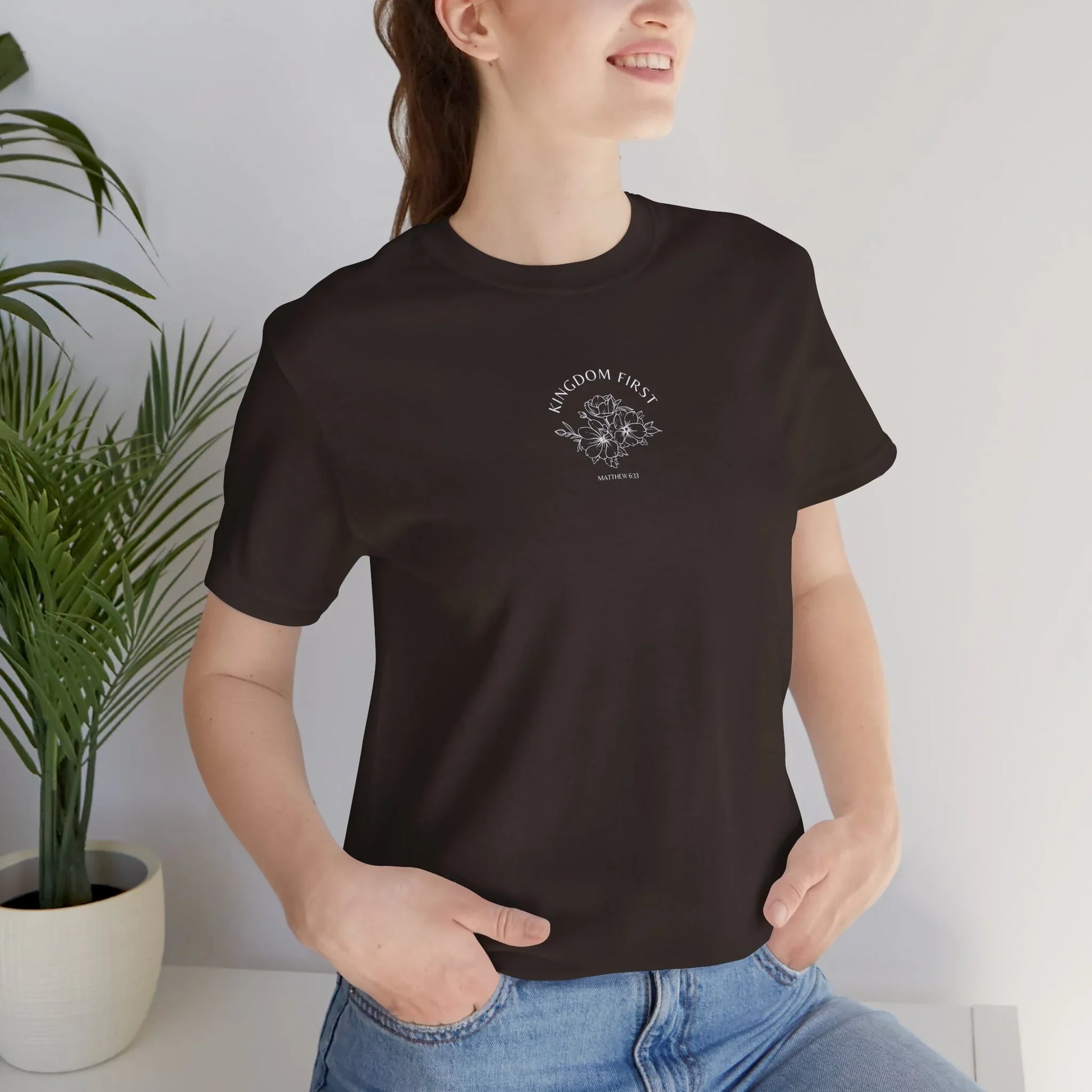 Woman wearing black Christian t-shirt with 'Kingdom First' and floral graphic, casual style