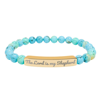 Blue beaded Christian bracelet with gold bar engraved 'The Lord is my Shepherd'.