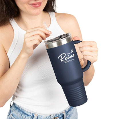 Woman in white tank top holding navy Christian travel mug with Spanish faith text