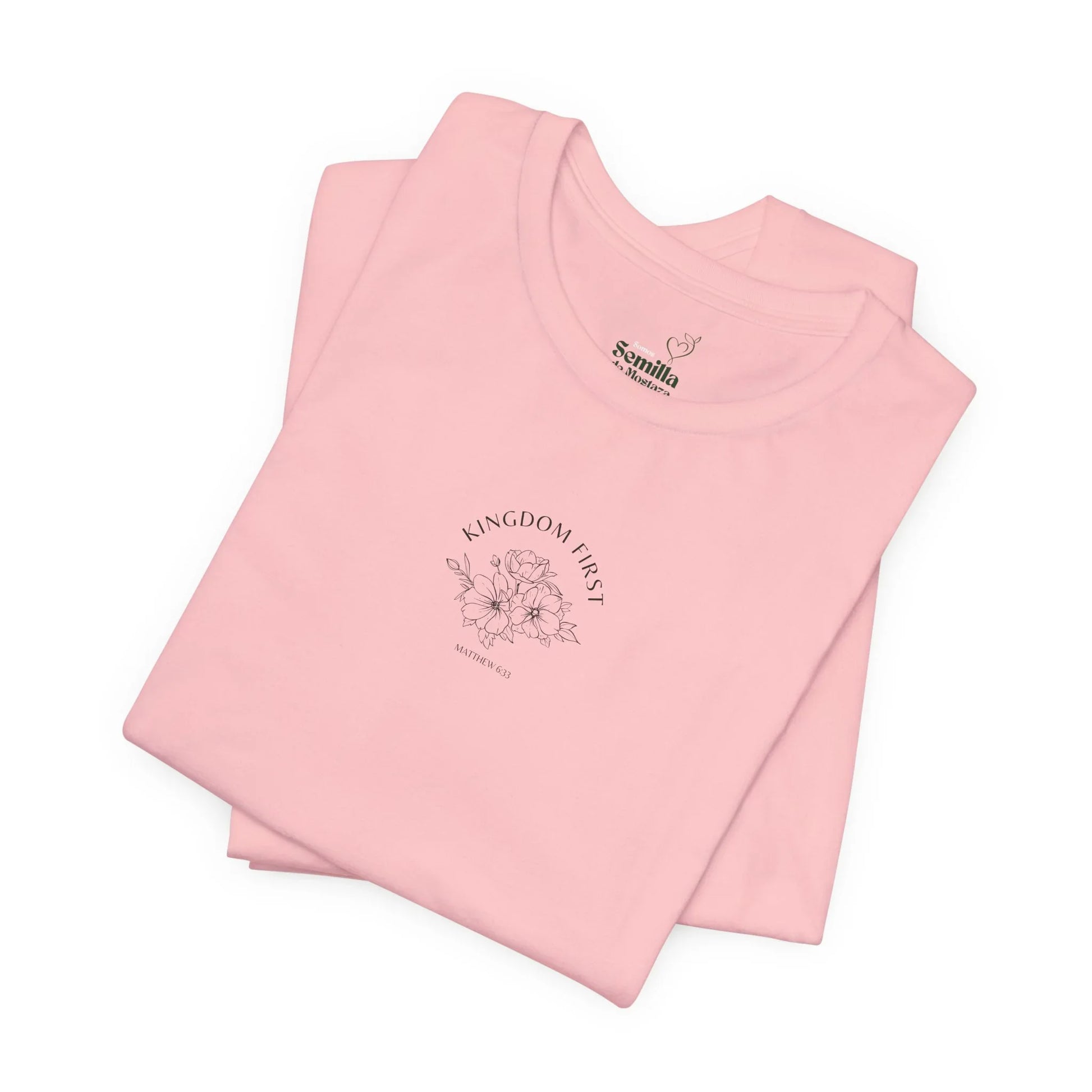Folded pink Christian t-shirt with 'Kingdom First' and floral design, Matthew 6:33 verse