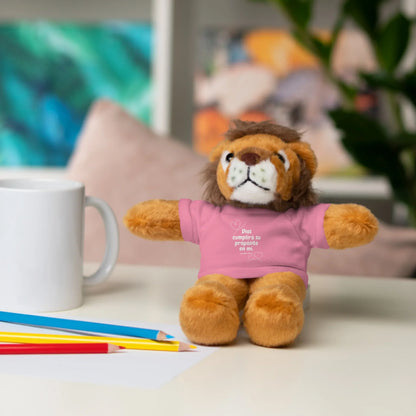 Plush lion toy in pink Christian message shirt on desk with coffee mug and colored pencils