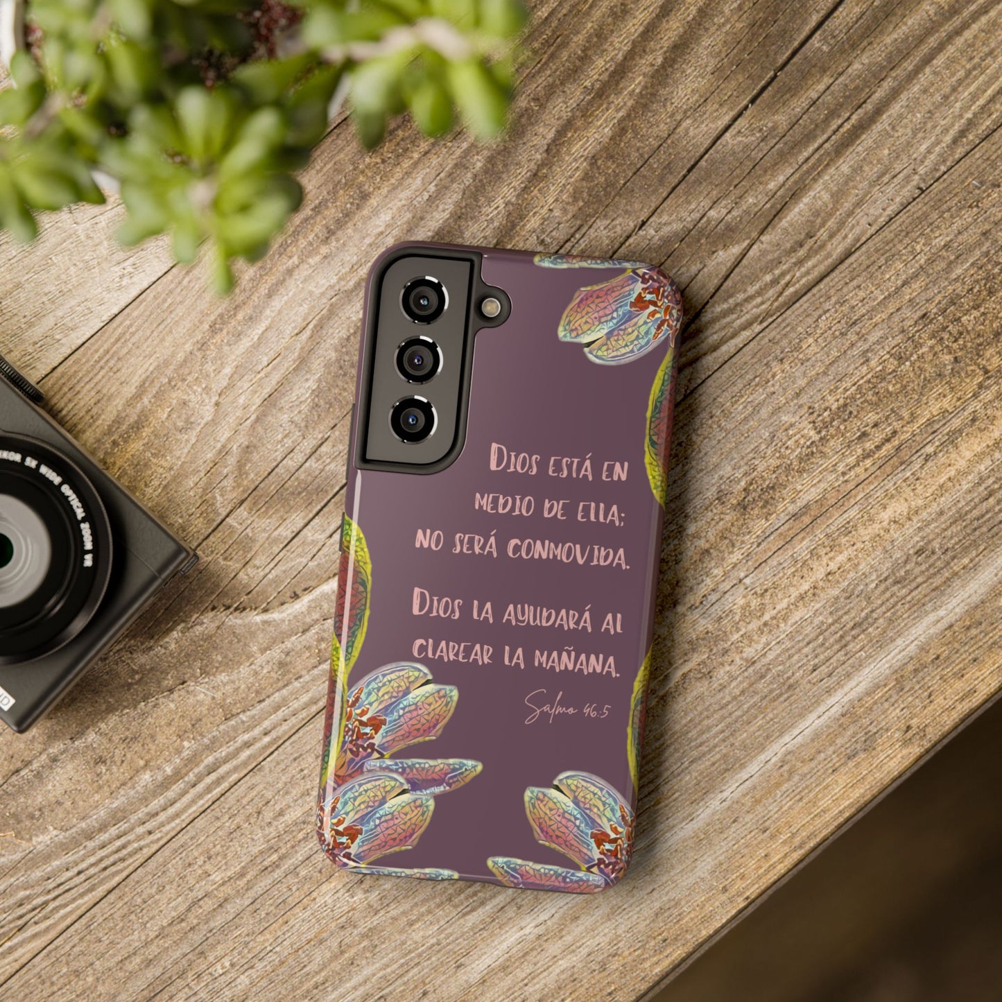 Christian phone case with Spanish Bible verse, floral design, on rustic wooden table