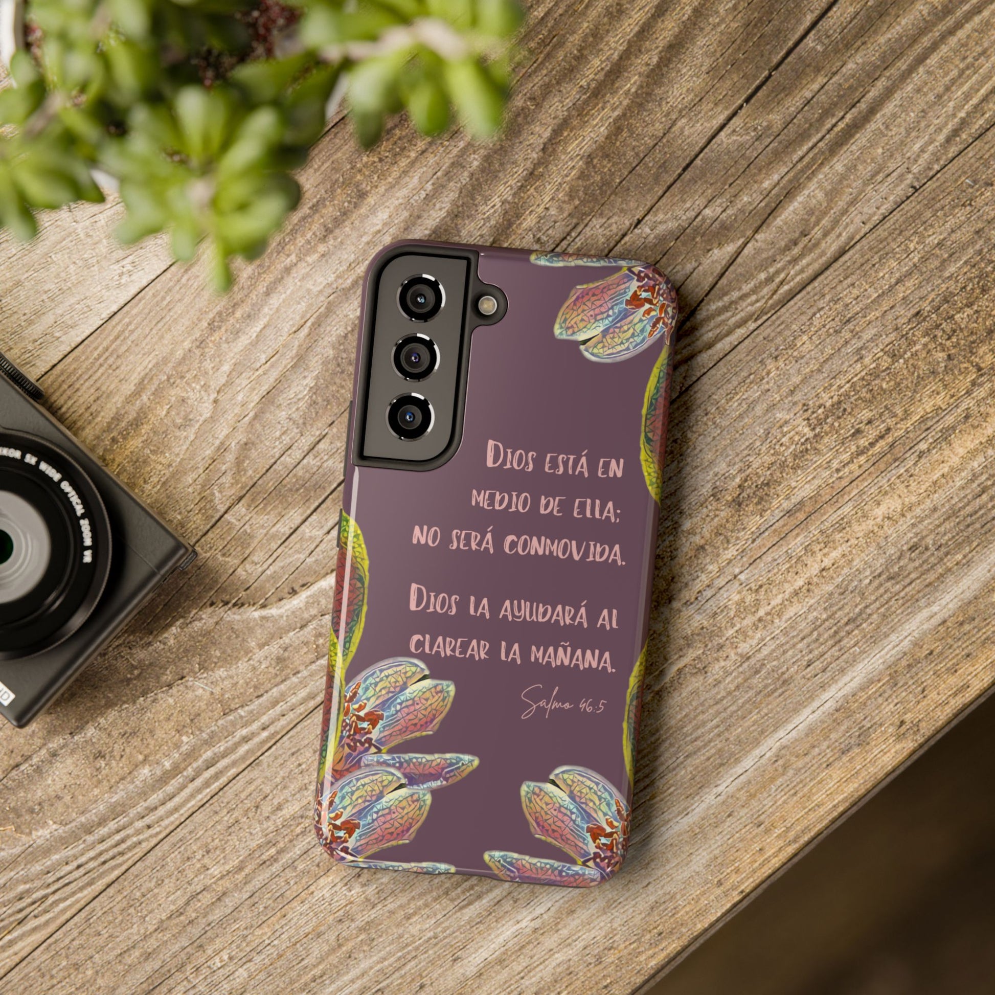 Christian phone case with Spanish Bible verse, floral design, on rustic wooden table