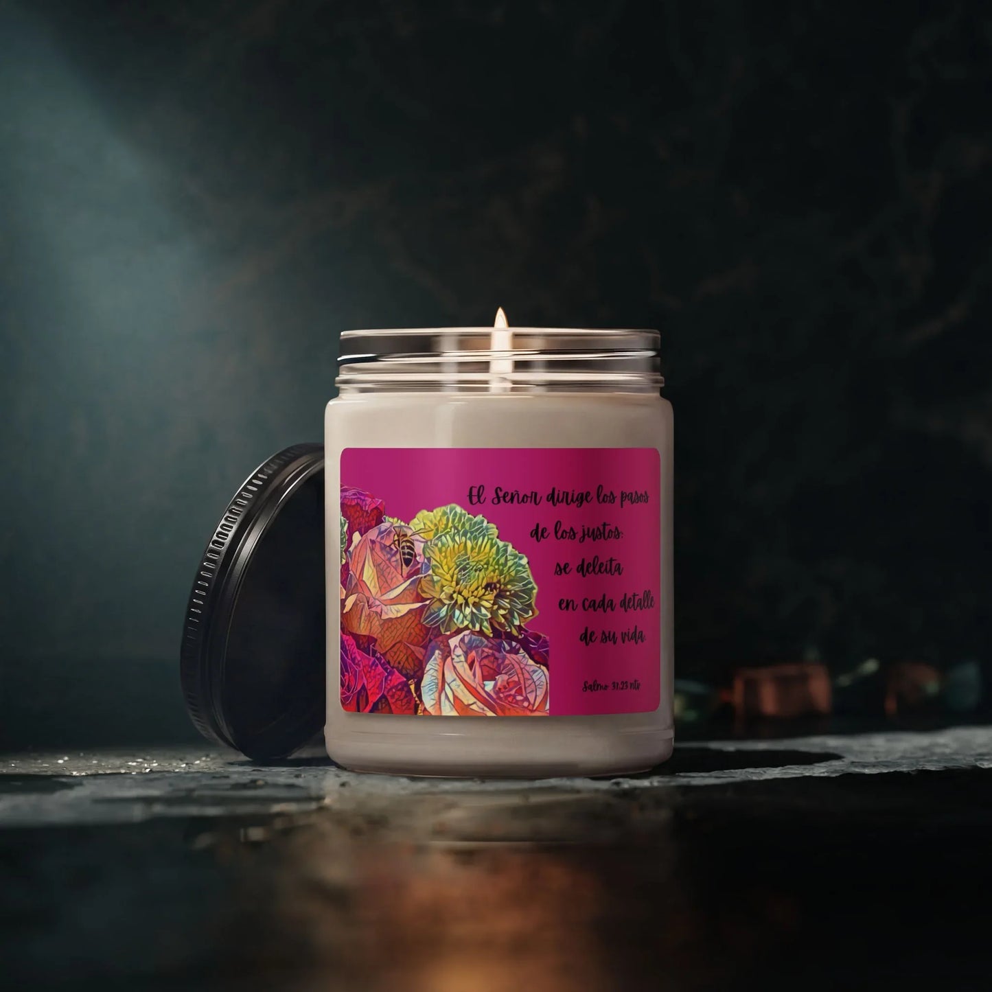 Christian scented candle with Spanish Scripture label and colorful floral design on a dark background