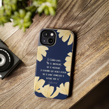 Christian phone case with Bible verse in Spanish, navy background, yellow floral design on wood table.