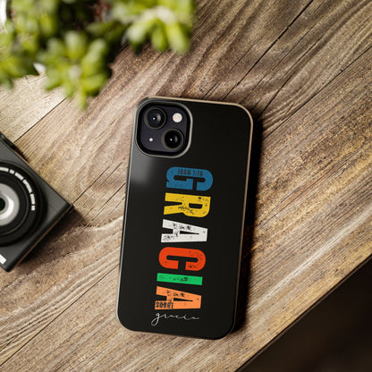 Black phone case with colorful Spanish Christian phrase and Bible verse on wooden table