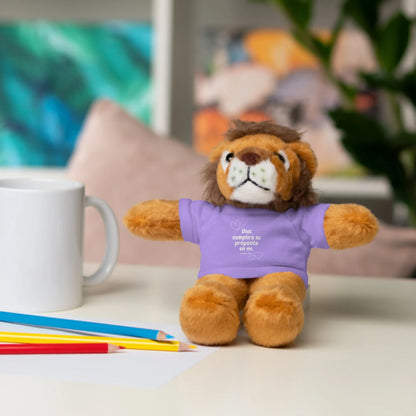 Plush lion toy in purple Christian t-shirt with Spanish scripture, mug and pencils on desk