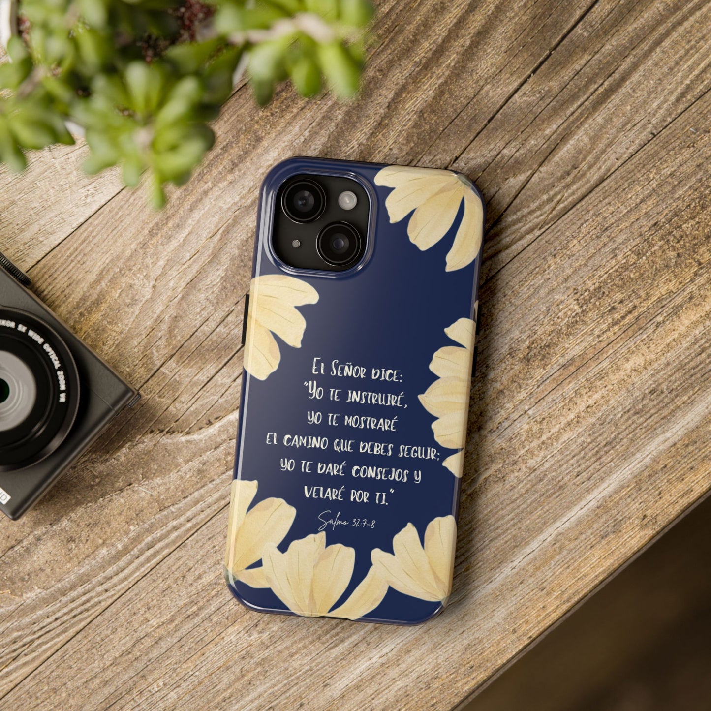 Navy blue Christian phone case with yellow floral design and Spanish Scripture text on wood table