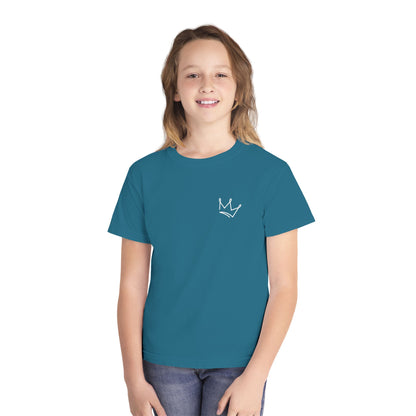 Smiling child in blue Christian t-shirt with white crown graphic, faith apparel