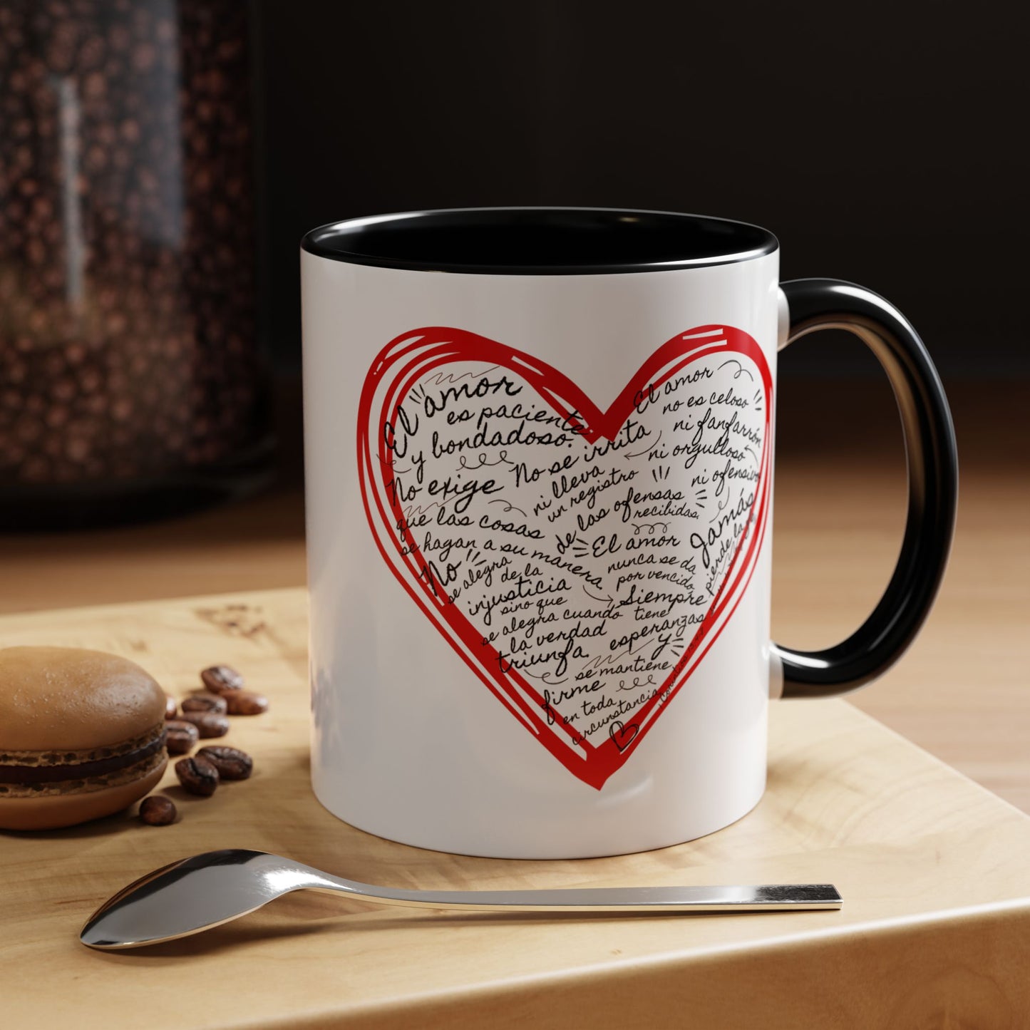 White ceramic mug with a red heart and Spanish Bible verse text, on a wooden table.