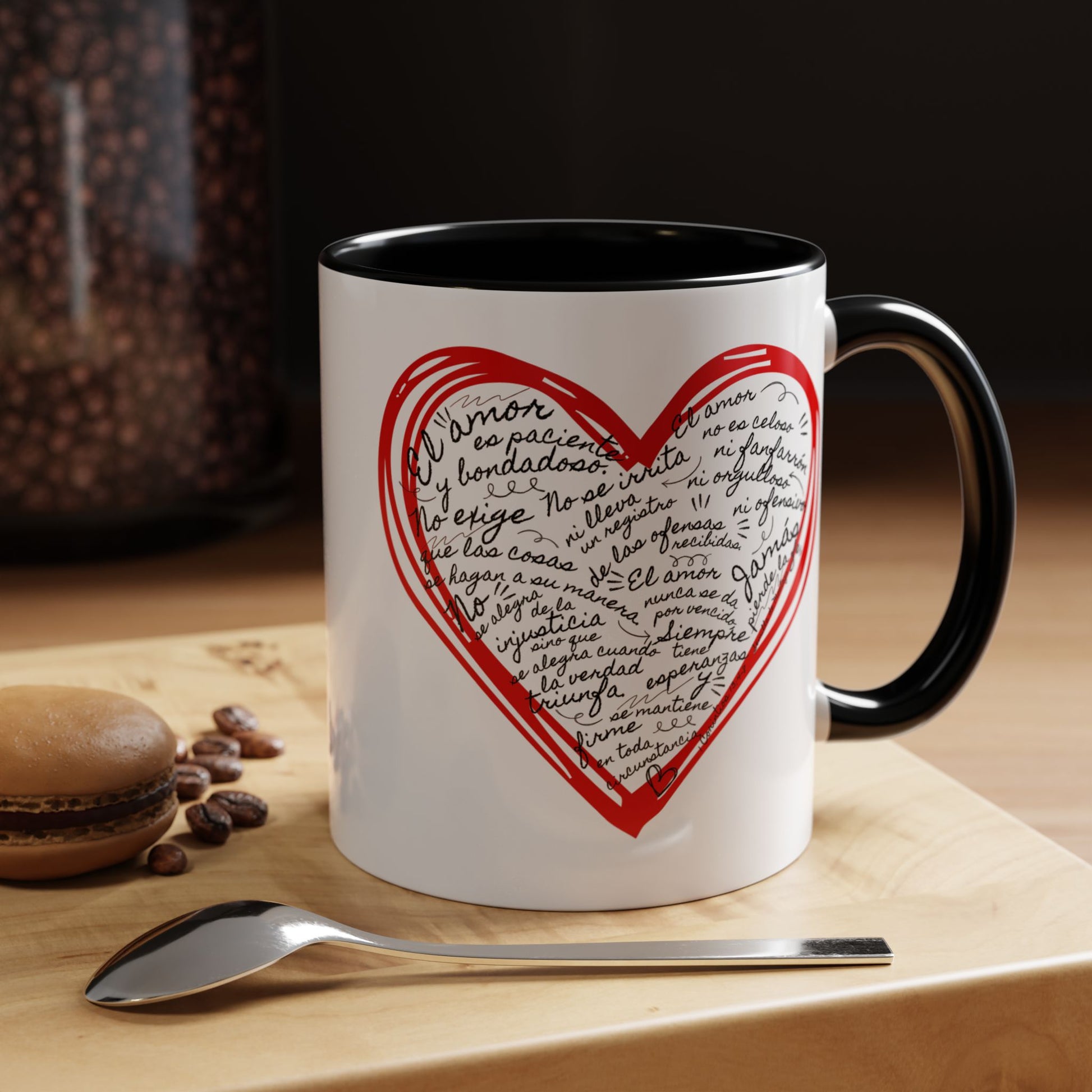White ceramic mug with a red heart and Spanish Bible verse text, on a wooden table.