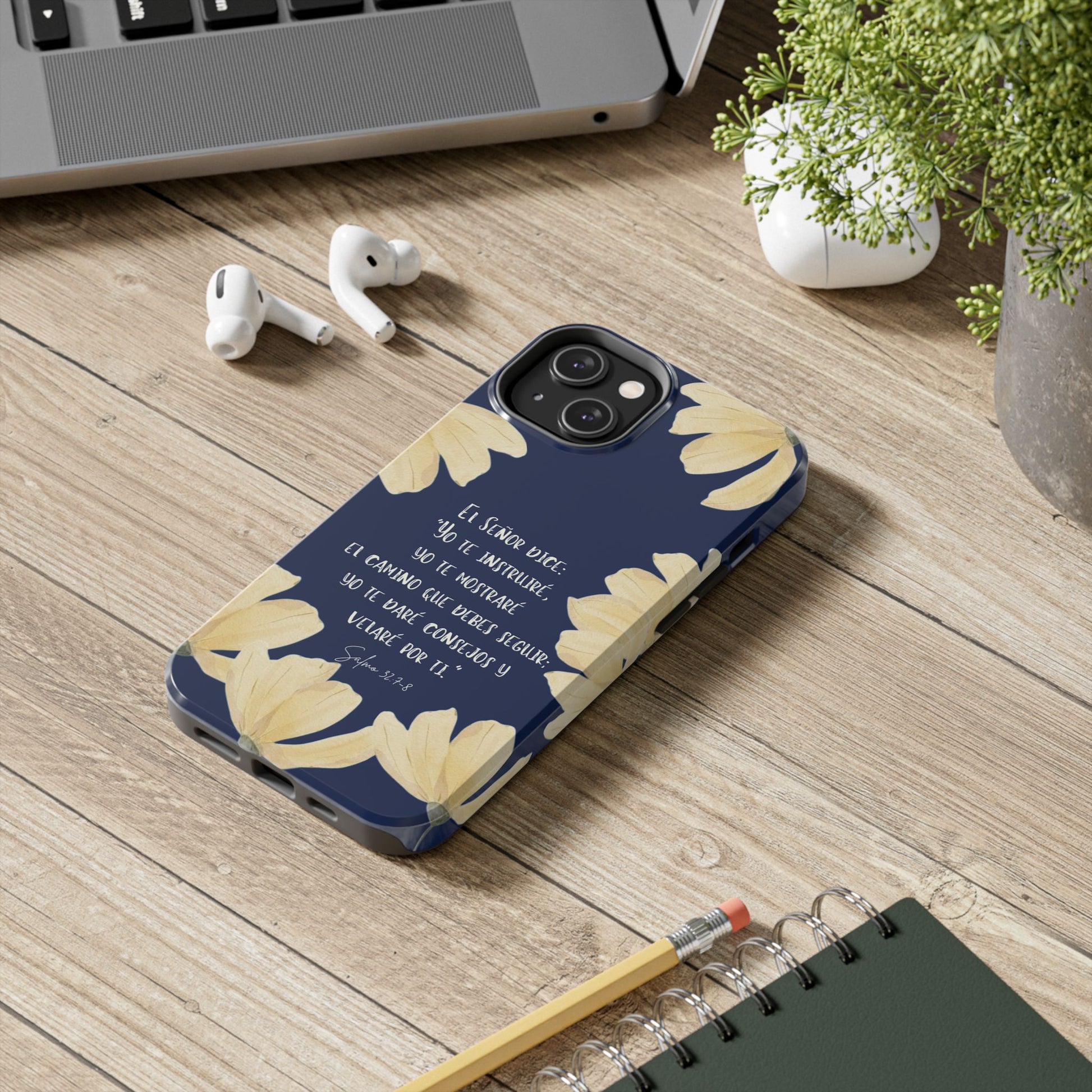 Christian floral phone case with Spanish Bible verse, on a desk with laptop and notebook