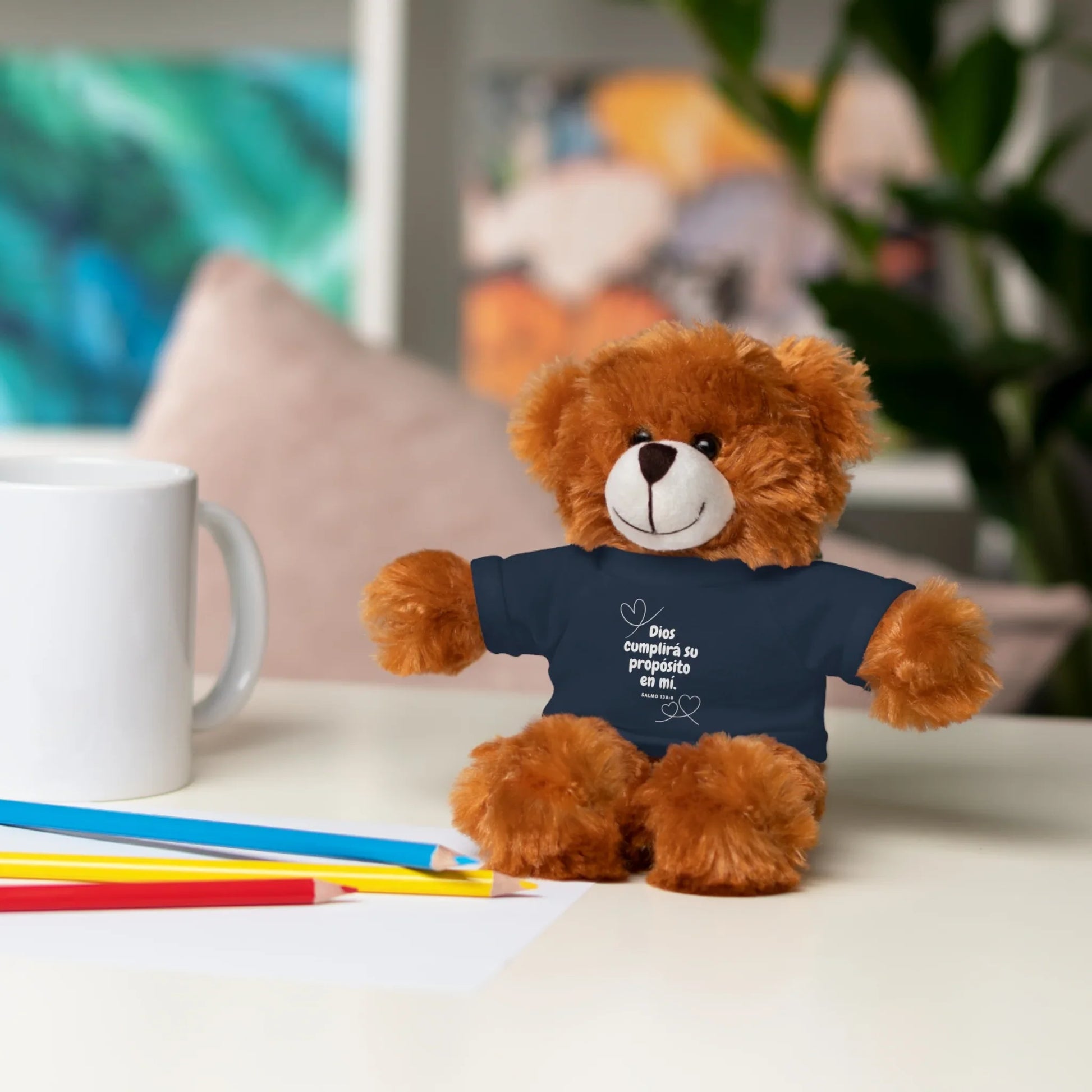 Christian teddy bear with Spanish scripture shirt on desk with pencils and mug
