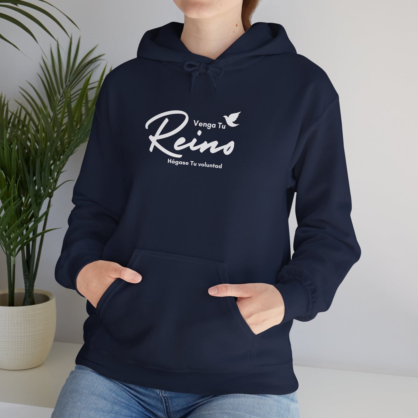 Woman wearing navy blue Christian hoodie with Spanish faith quote and dove design