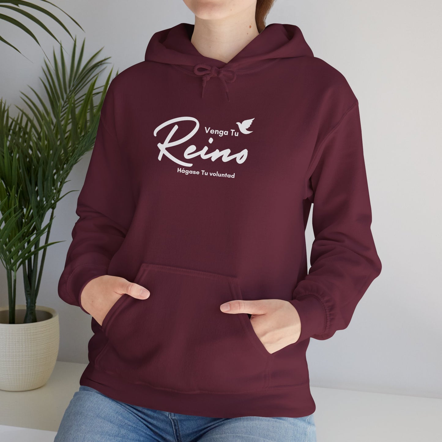 Woman wearing maroon Christian hoodie with Spanish faith quote and dove graphic