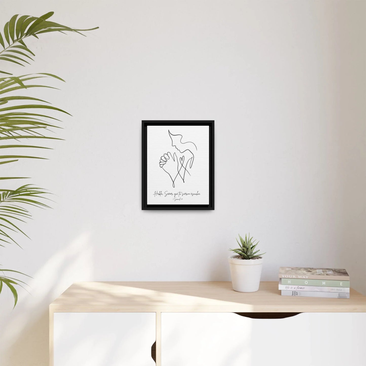 Minimalist Christian wall art with praying hands above a modern sideboard, indoor décor