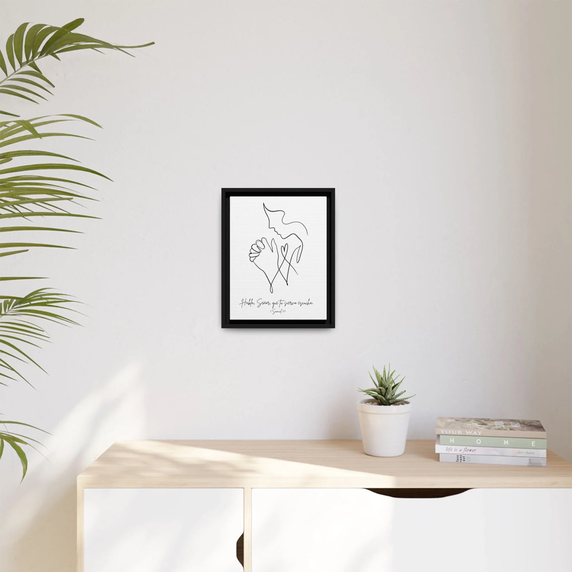 Minimalist Christian wall art with praying hands above a modern sideboard, indoor décor