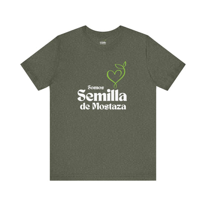 Heather green t-shirt with 'Somos Semilla de Mostaza' and green heart plant graphic.