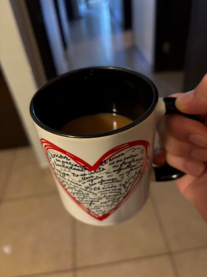 Hand holding Christian mug with heart and handwritten Bible verse design in Spanish