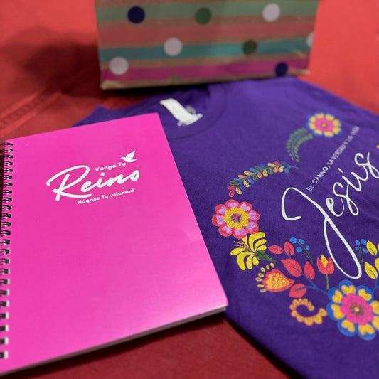 Pink Christian faith journal and purple floral Jesus t-shirt on red surface