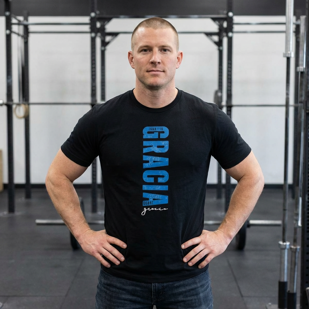 Man in gym wearing black Christian t-shirt with 'GRACIA' and Scripture design