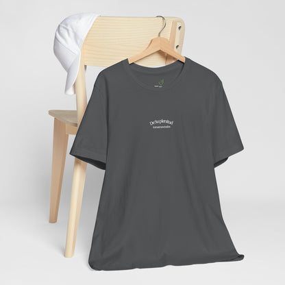 Charcoal Christian t-shirt with Spanish faith message on hanger, white cap on wooden chair