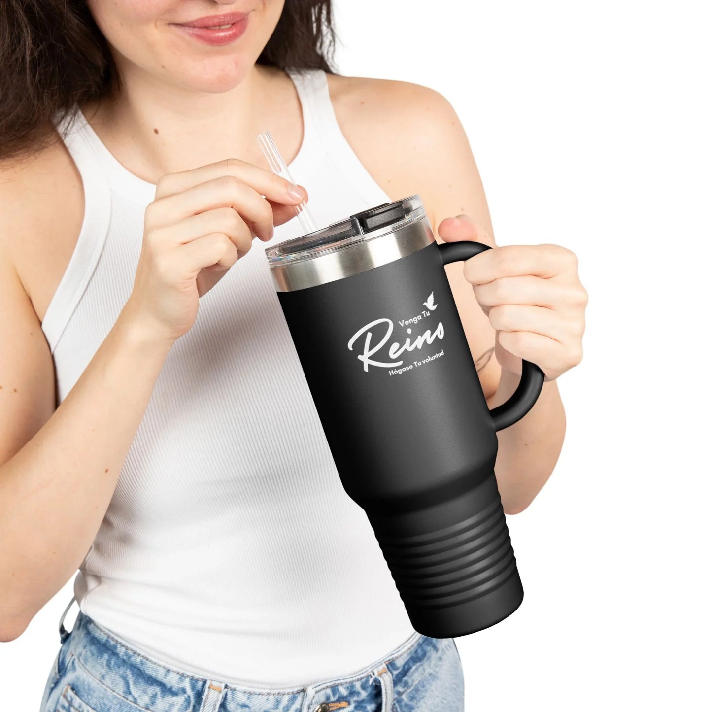 Woman holding black Christian travel mug with Spanish faith message, wearing white tank top