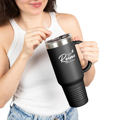 Woman holding black Christian travel mug with Spanish faith message, wearing white tank top