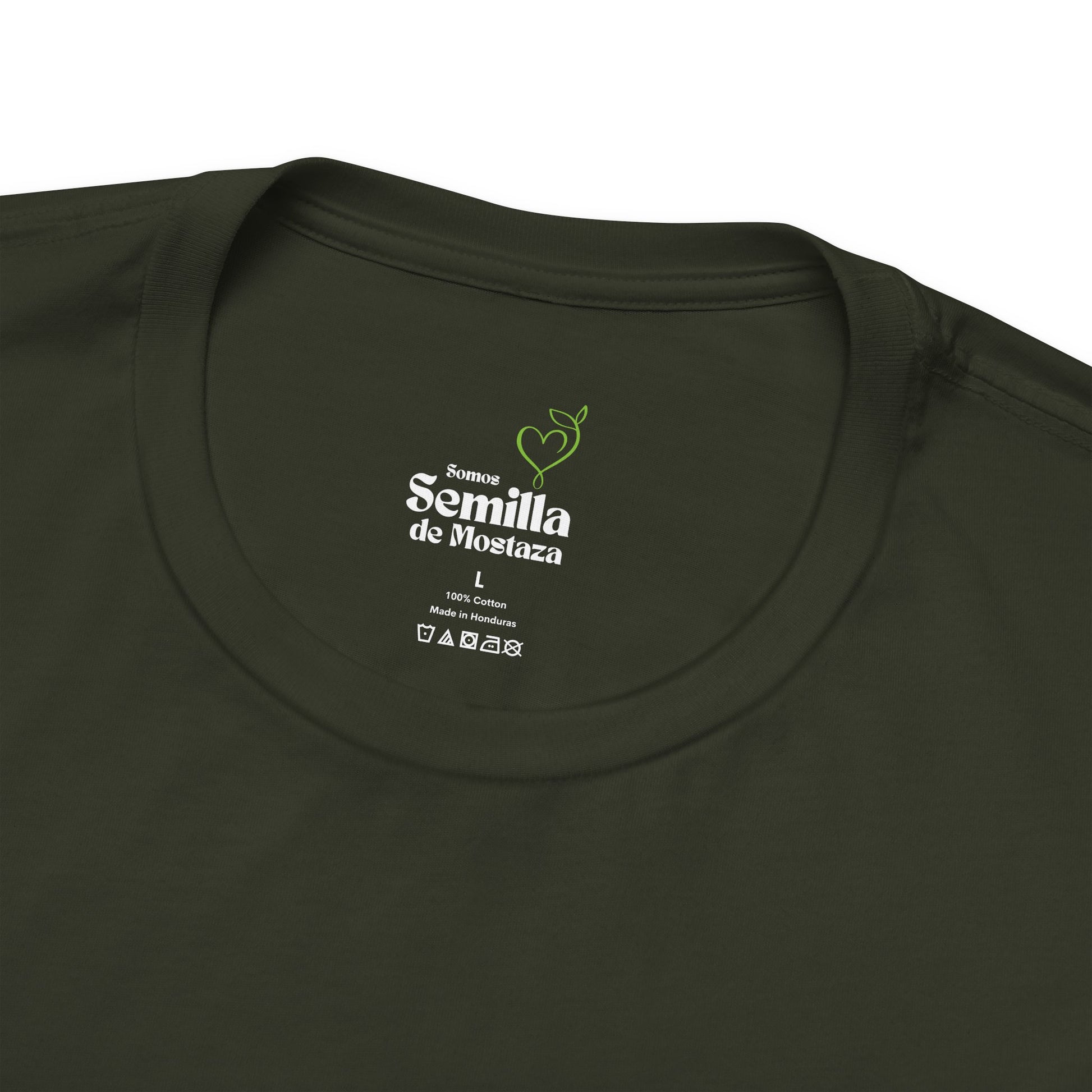 Close-up of olive green Christian t-shirt neck label with 'Somos Semilla de Mostaza' text.