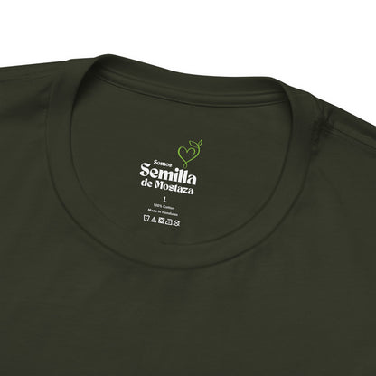 Close-up of olive green Christian t-shirt neck label with 'Somos Semilla de Mostaza' text.