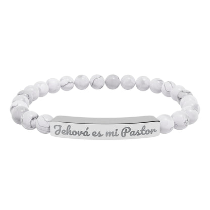 White beaded Christian bracelet with metal bar engraved 'Jehová es mi Pastor'.