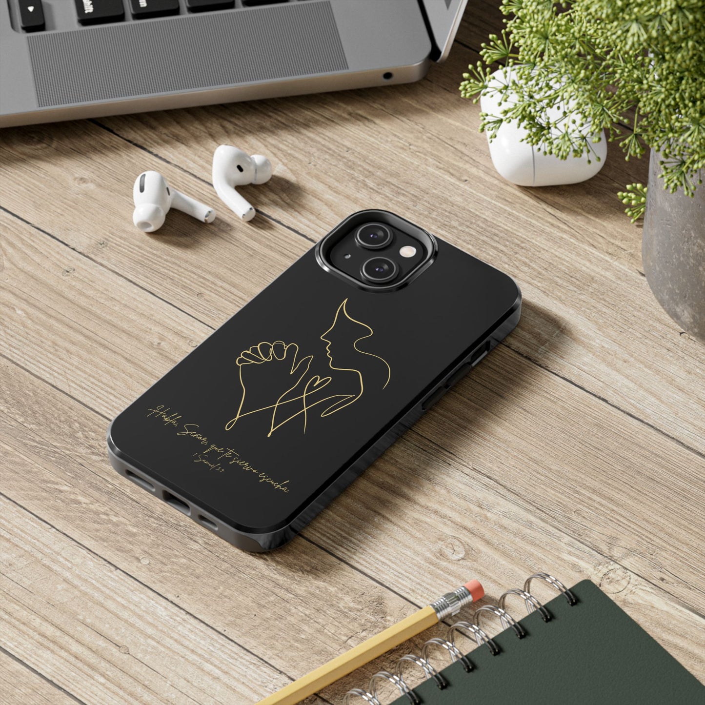 Black Christian phone case with gold praying hands line art, inspirational text, on a desk