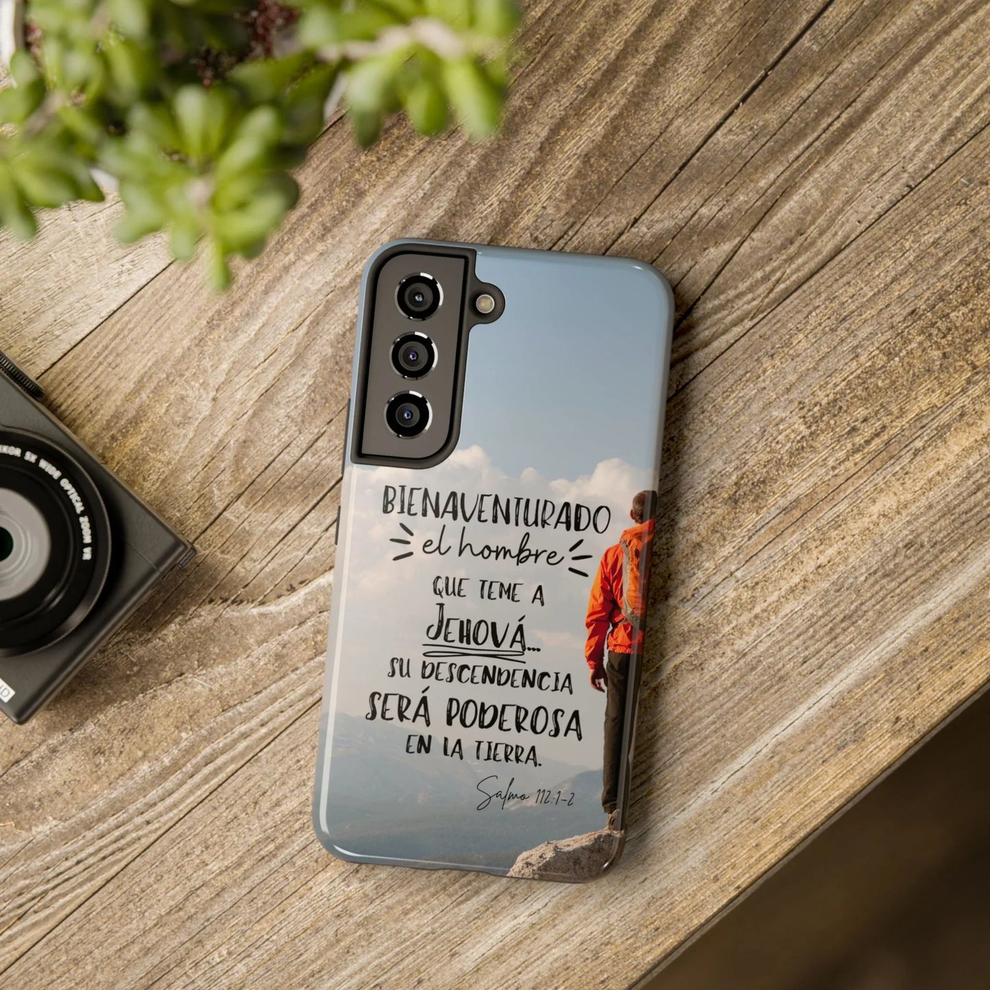 Christian phone case with Psalm 112:1-2 in Spanish, man on mountain design, wood table setting