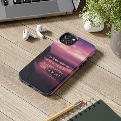 Christian phone case with Spanish Bible verse, next to earbuds and notebook on a wooden desk.