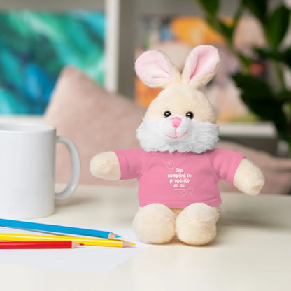 Plush bunny with pink Christian message shirt on desk with mug and colored pencils
