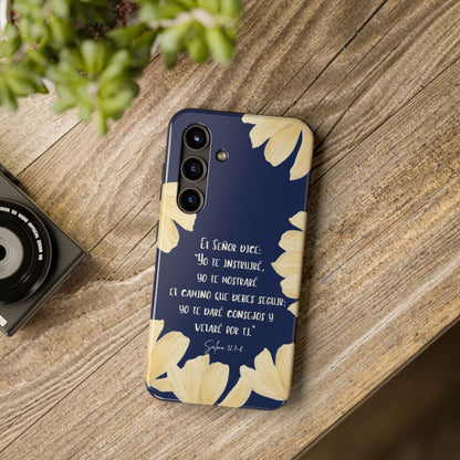 Christian phone case with Spanish Bible verse, floral design, on wood table next to camera.