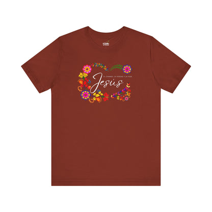Brown T-shirt with colorful floral design and Spanish Christian text about Jesus.