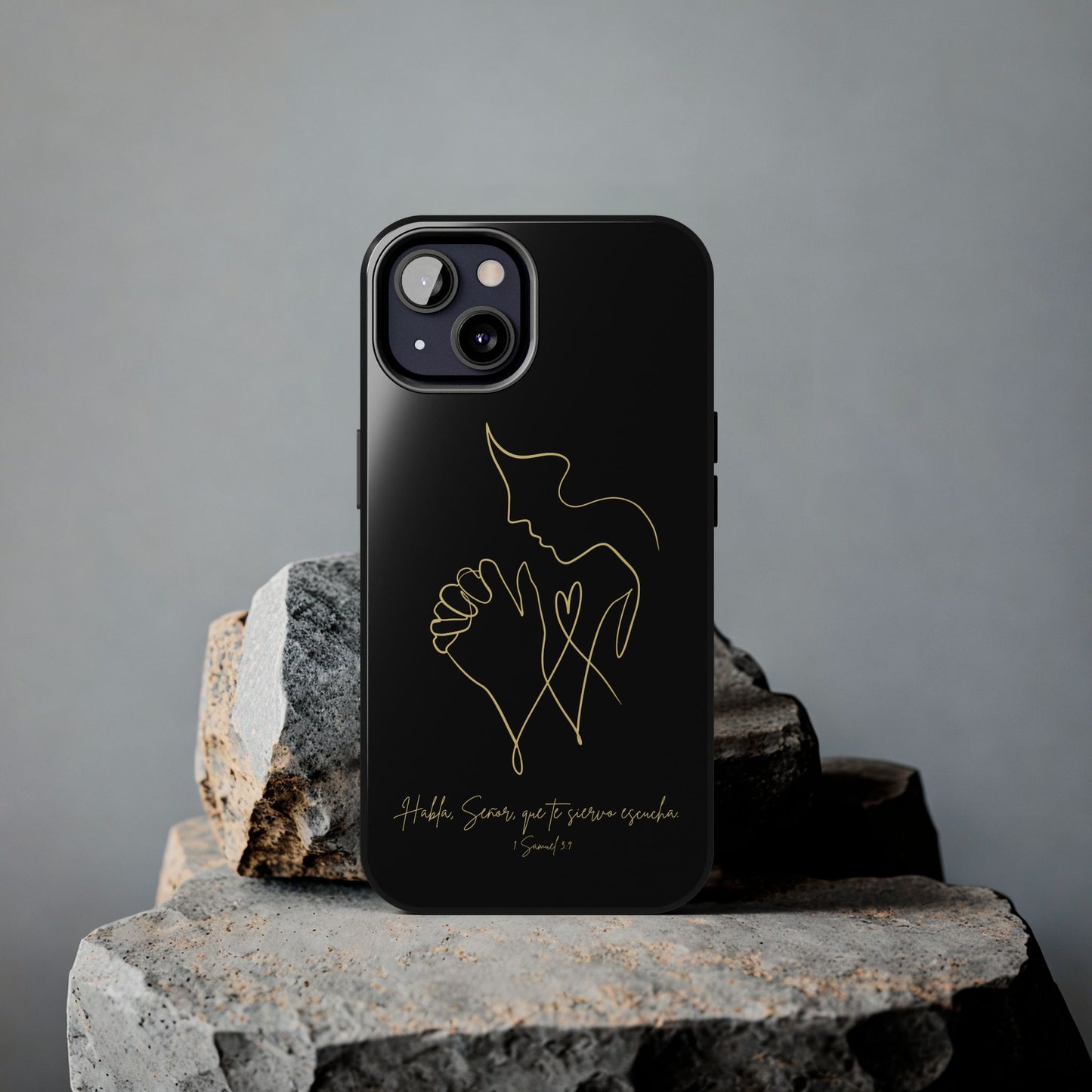 Black Christian phone case with gold praying figure design and Spanish Bible verse, on stone.