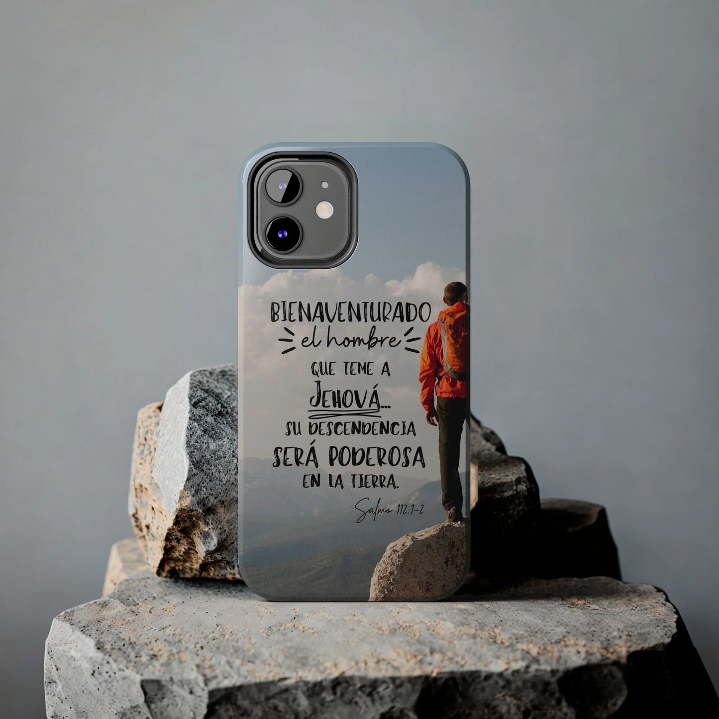 Christian phone case with Spanish Bible verse, hiker design, displayed on stone background