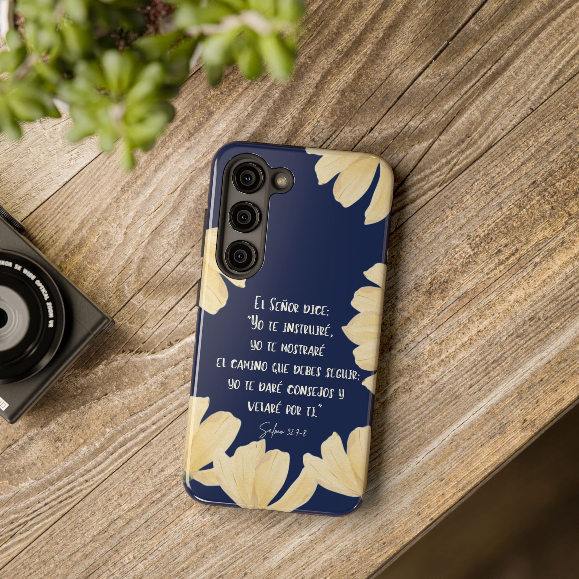 Christian floral phone case in Spanish with Scripture, placed on rustic wood table