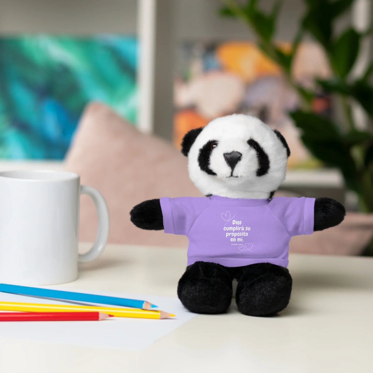 Plush panda toy in lavender Christian t-shirt with Spanish Scripture on desk with mug and pencils