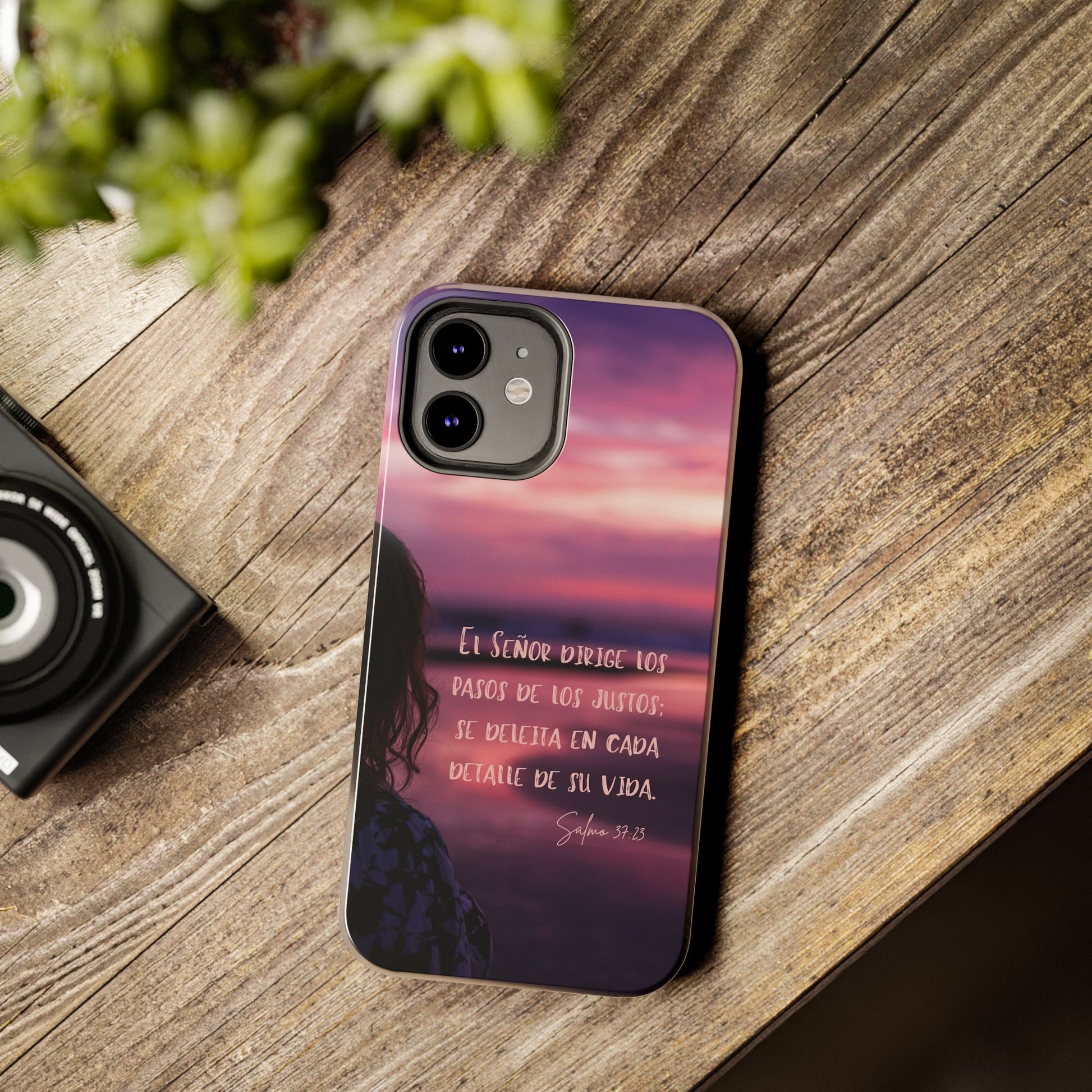 Christian phone case with Spanish scripture, sunset background, on wooden table