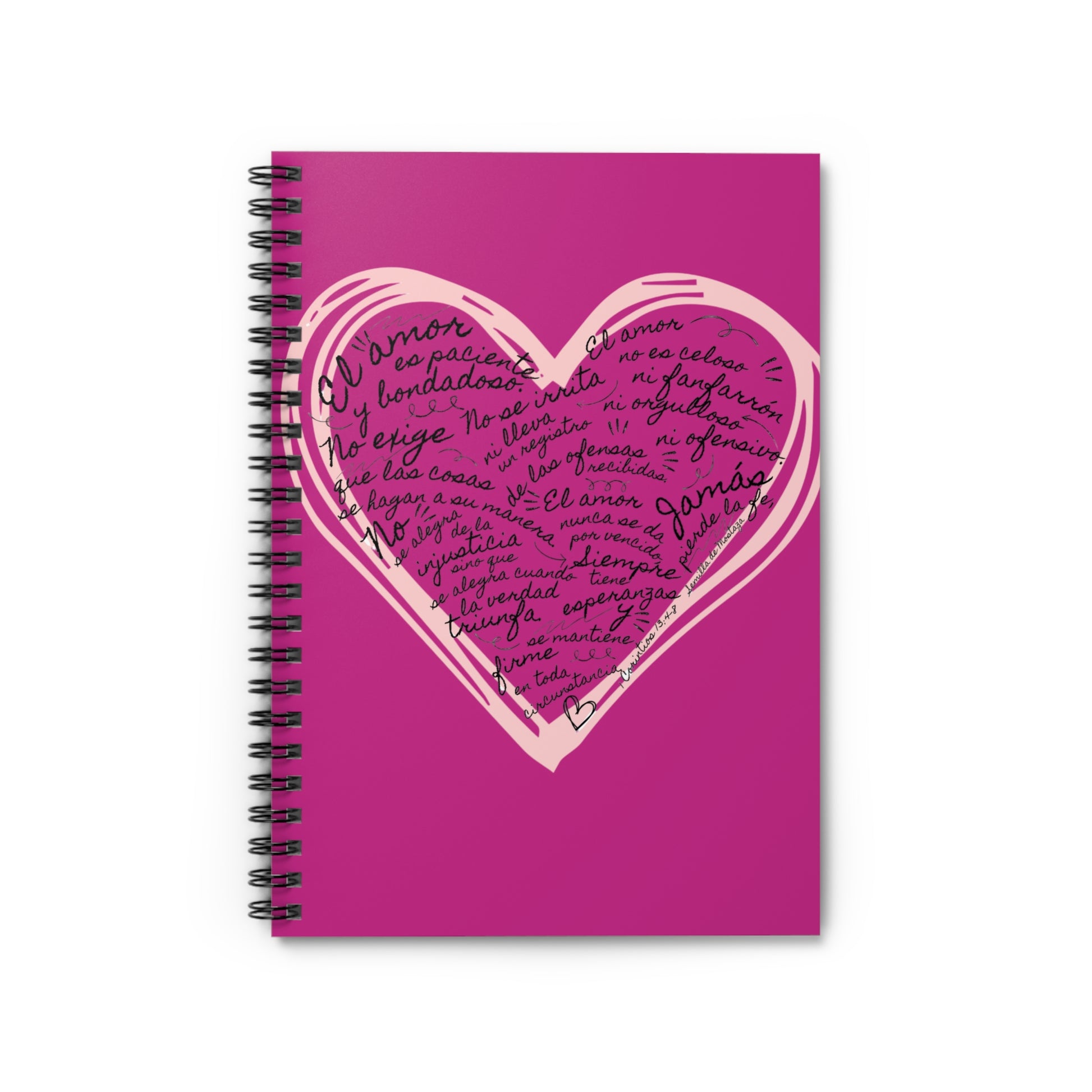 Pink spiral notebook with a heart and handwritten Spanish Christian scripture text on the cover.