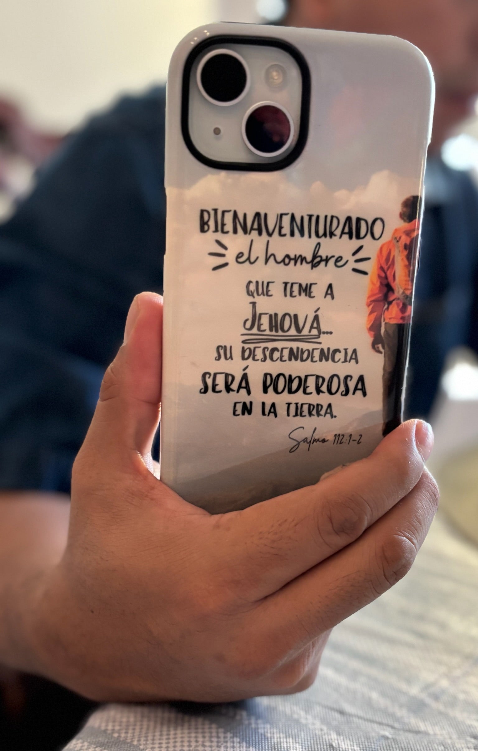 Phone case with the text of Psalm 112:1-2 in Spanish and a person holding it